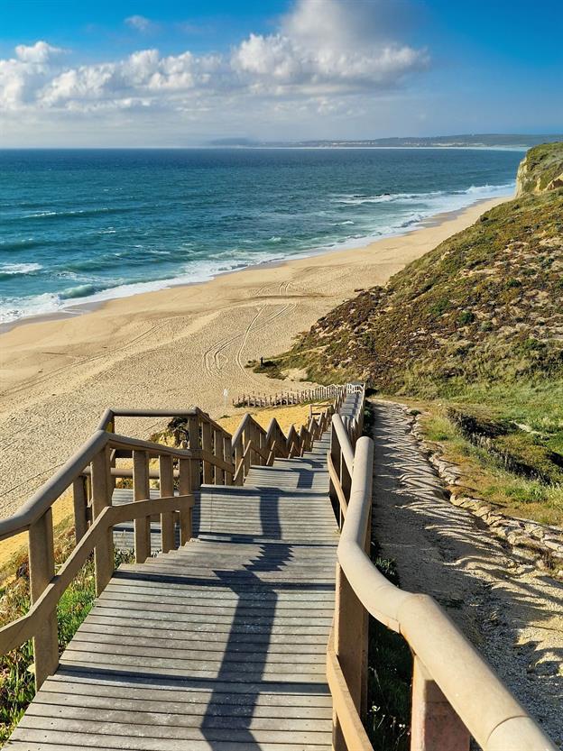 Eine malerische Holztreppe schlängelt sich hinunter zum Strand "Praia das Bicas" in Castelo, westlich von Sesimbra.
(05.2024)